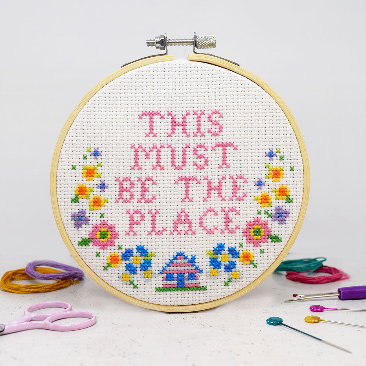 cross stitch design with This is the place slogan and flowers and house motifs