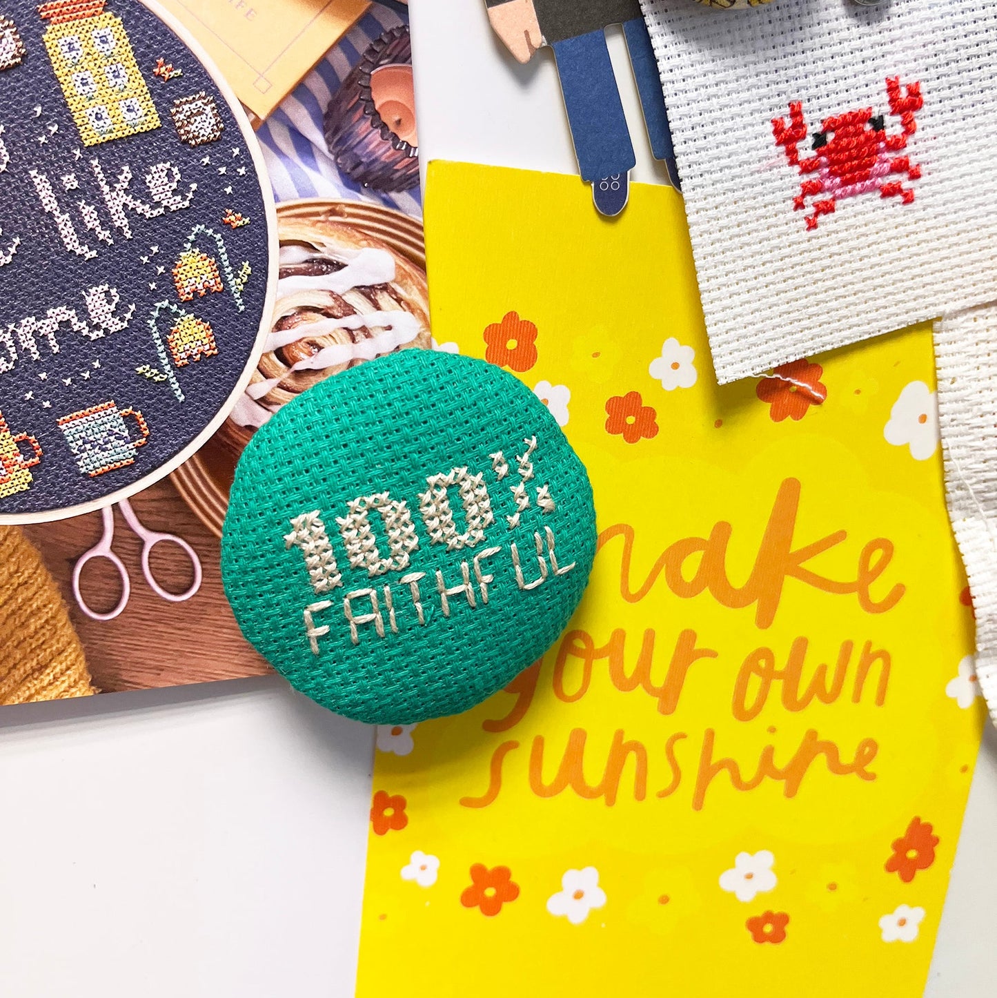 A notice board with green cross stitched magnet with the slogan 100% Faithful on it.