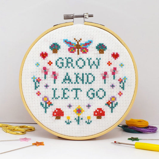 cross stitch design with grow and let go slogan and flowers