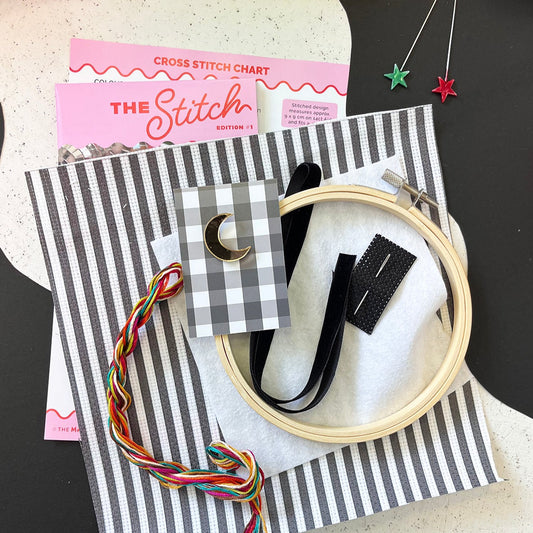 Embroidery hoop, thread, striped black and white aida and chart.