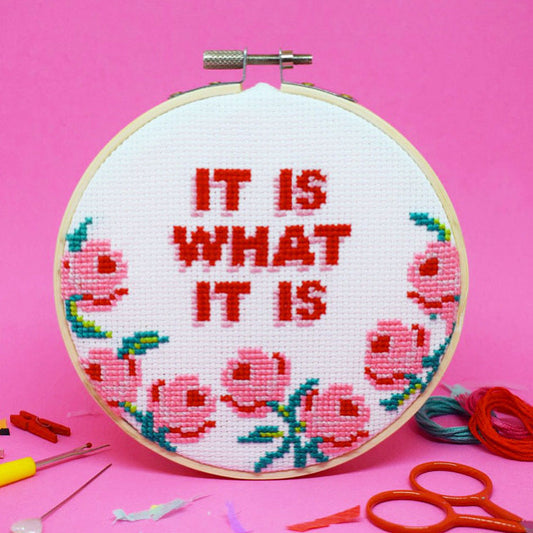 cross stitch design with it is what it is slogan and large pink roses
