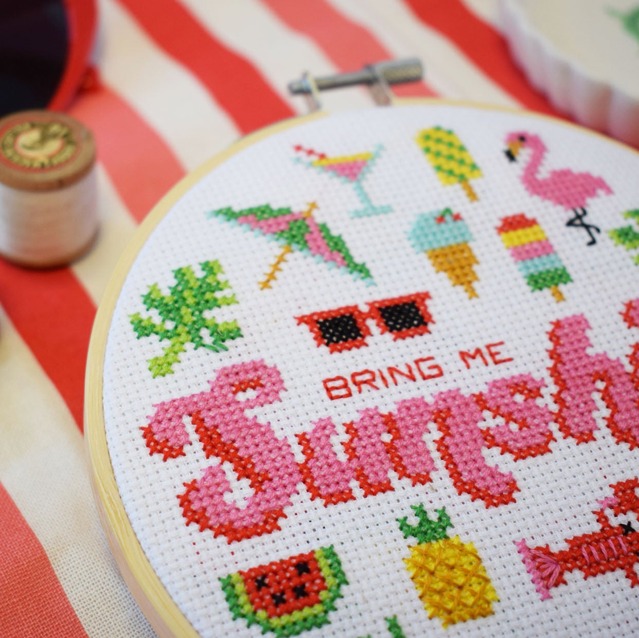 close up photo of the Bring Me Sunshine cross stitch kit with colourful stitch design in pink and red