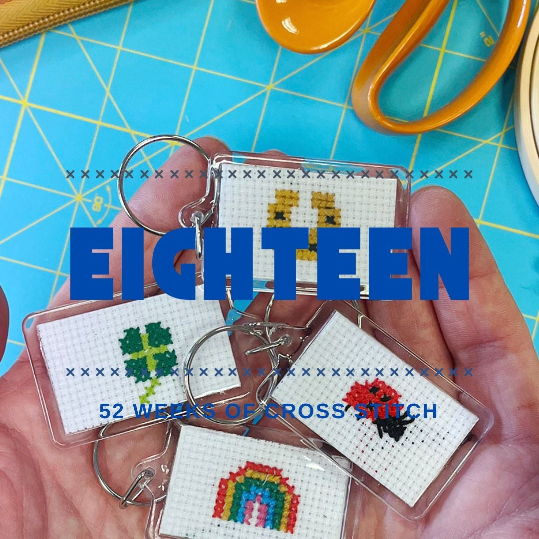 Cross-stitched keychains held in hands with 'EIGHTEEN' text and scissors in the background.
