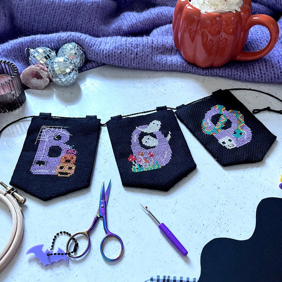 halloween cross stitch garland with the word 'BOO' spelt across it.