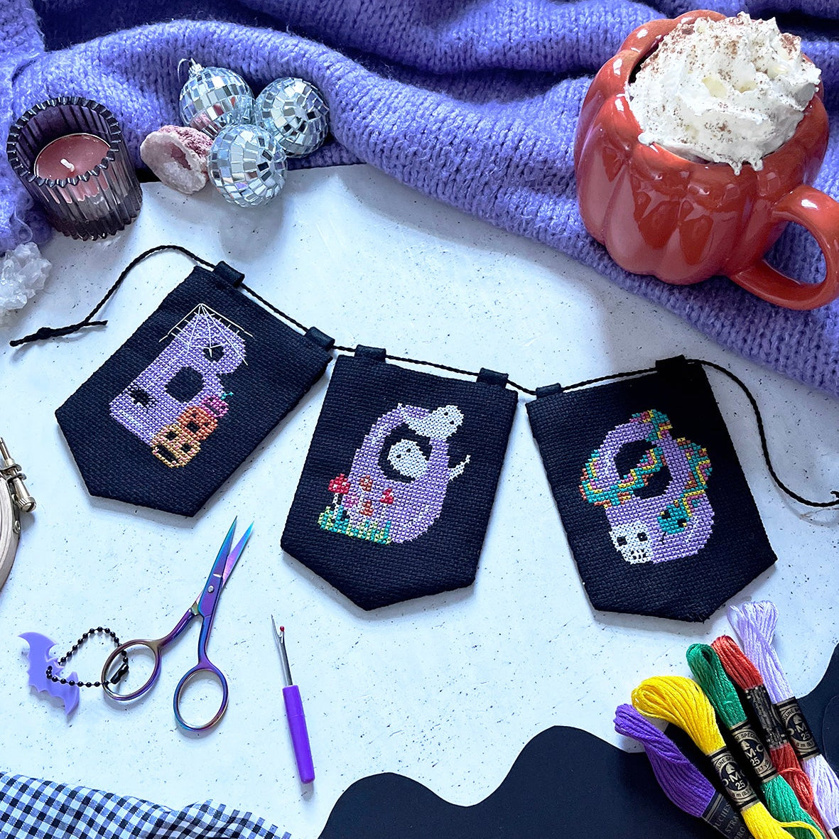halloween cross stitch garland with the word 'BOO' spelt across it.