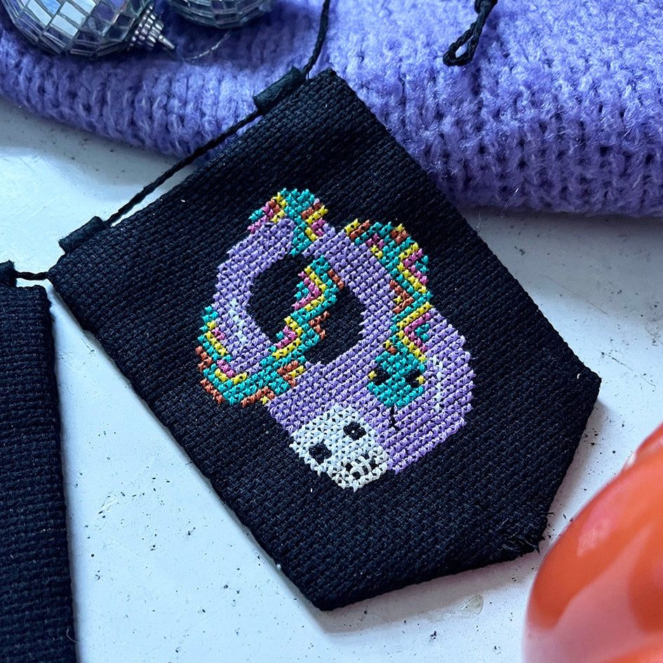 halloween cross stitch garland with the word 'BOO' spelt across it.