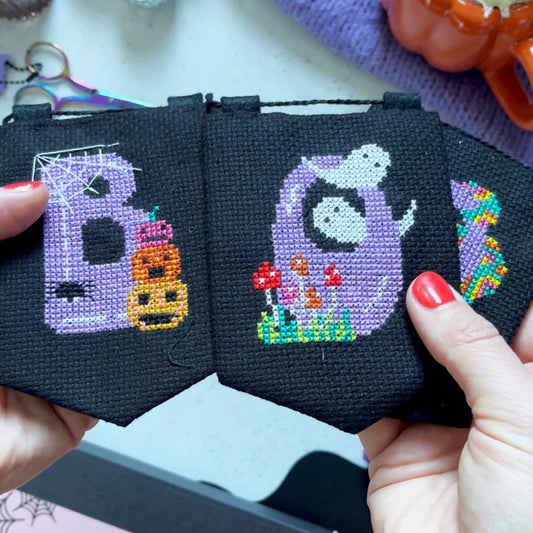 halloween cross stitch garland with the word 'BOO' spelt across it.