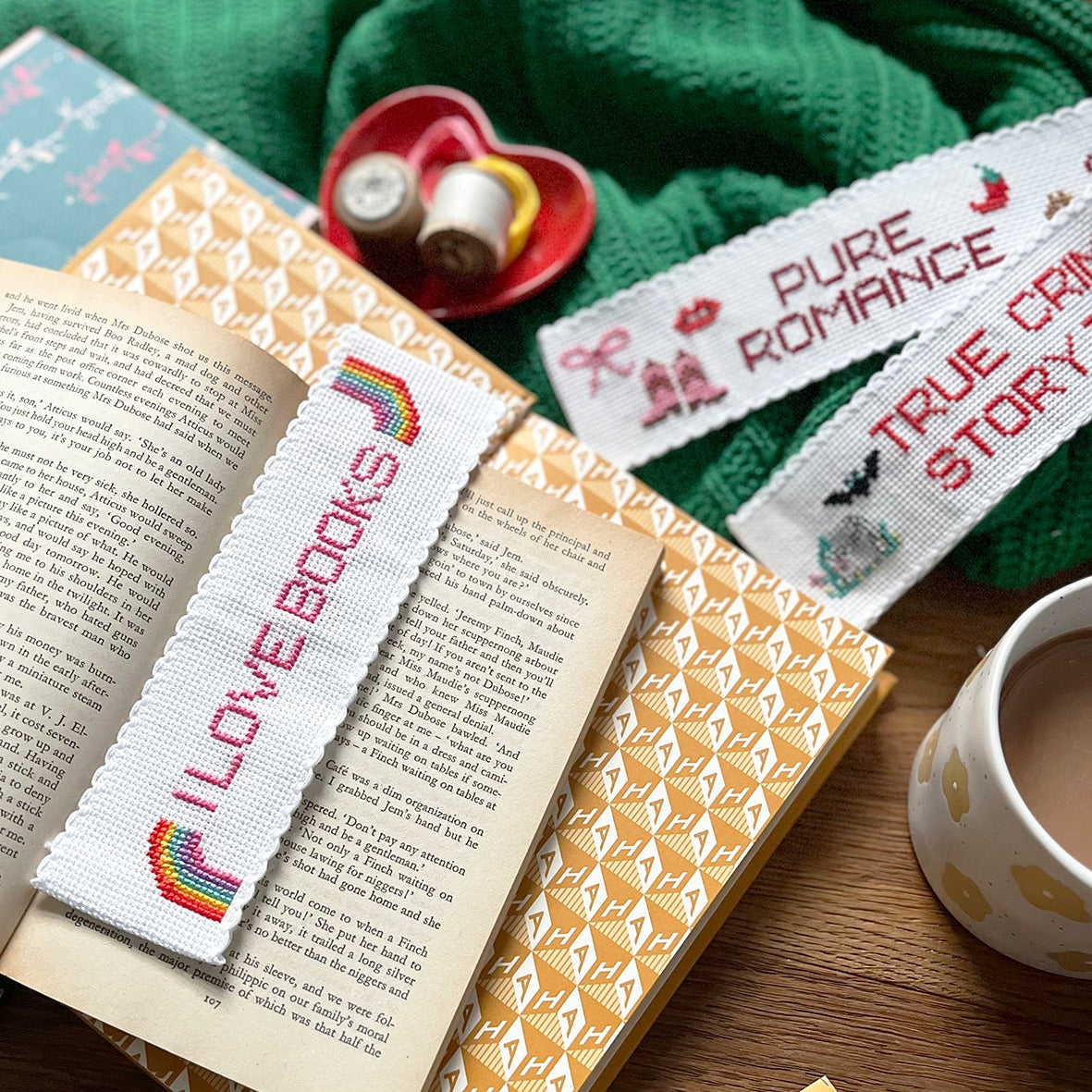 Open book with bookmarks and a cup of coffee on a wooden surface