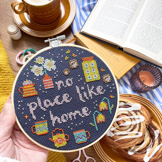 cross stitch hoop with 'no place like home' motto and tea, coffee, flowers and pastries design.