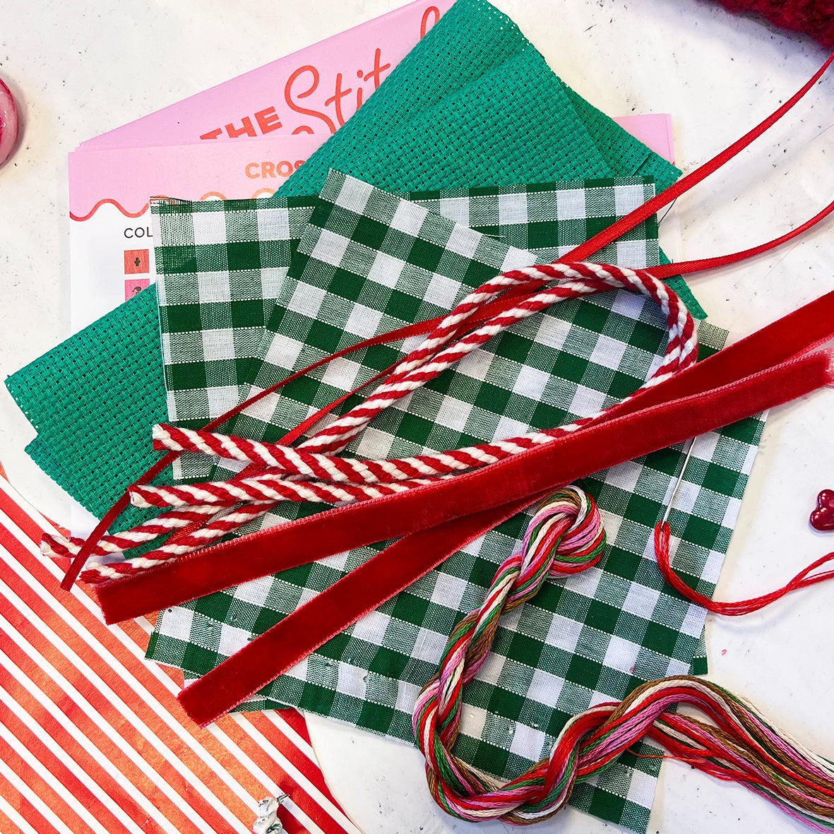 selection of fabrics and trims to make the cross stitch designs