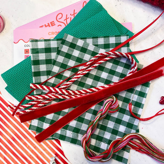 selection of fabrics and trims to make the cross stitch designs